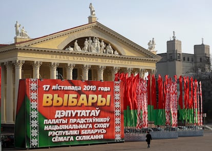 A woman walks past a huge election banner and Belarus national flags in Minsk, Belarus, on Nov. 13, 2019.
