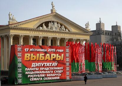 A woman walks past a huge election banner and Belarus national flags in Minsk, Belarus, on Nov. 13, 2019.