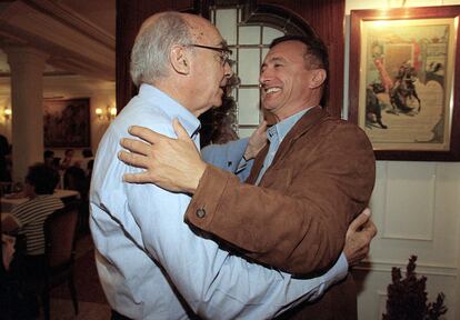 José Saramago y Arturo Pérez-Reverte se saludan en la Feria del Libro del año 2002.