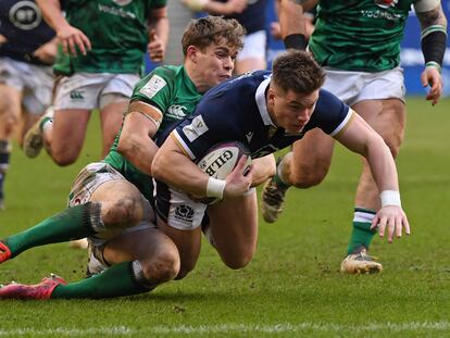 El escocés Huw Jones se lanza sobre la línea para anotar un try a pesar de la entrada del centro irlandés Garry Ringrose