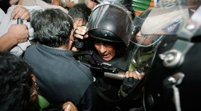 Policías antidisturbios intentan impedir el paso a los manifestantes a una sede bancaria en La Paz.