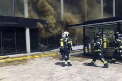 Fotografía facilitada por el Ayuntamiento de Madrid que muestra a integrantes del cuerpo de Bomberos durante la extinción de un incendio que se ha originado en una cocina de un restaurante del Paseo de la Castellana, junto a la zona empresarial de las Cuatro Torres.