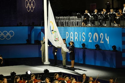 Izada de la bandera de los Juegos Olímpicos mientras se escucha su himno. 