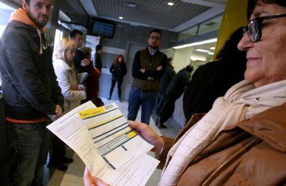 Un grupo de personas espera su turno para ejercer su opci&oacute;n de voto a distancia en una oficina de Correos en Madrid.