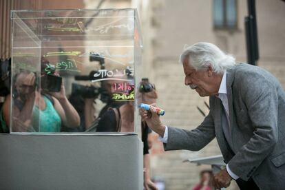 El diseñador Lluis Juste de Nin, firma una urna gigante en el inicio del acto en el que la cultura catalana ha reclamado poder votar.