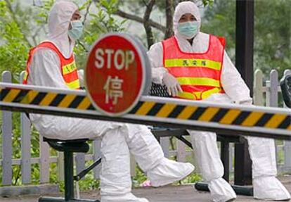 Vigilantes a la entrada de un campo de aislamiento de afectados por la neumonía en Hong Kong.