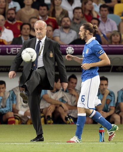 Spain head coach Vicente del Bosque, left, kicks the ball as Italy's Federico Balzaretti tries to take a throw-in during the Euro 2012 soccer championship final between Spain and Italy in Kiev, Ukraine, Sunday, July 1, 2012. (AP Photo/Ivan Sekretarev)