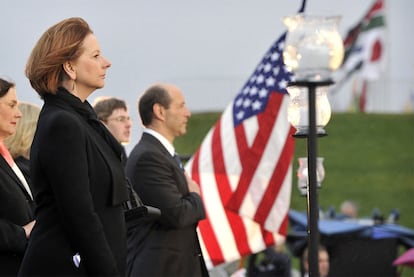 La primera ministro australiana, Julia Gillard, escucha el himno junto a la bandera de las barras y estrellas junto al embajador de EEUU, Jeffrey Bleich, durante el acto de homenaje al 11-S.