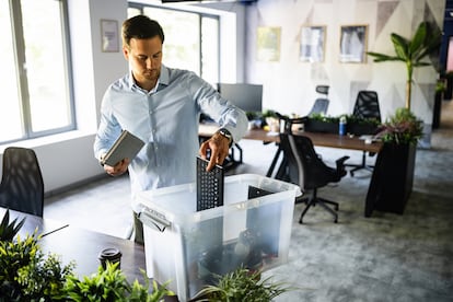 Young Caucasian businessman packing his belongings from the office, after he get fired