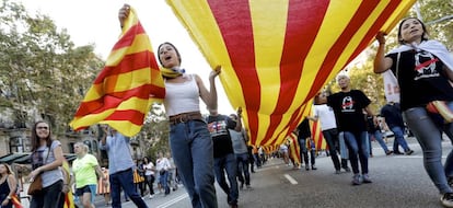 Various people carry a flag through the streets of Barcelona during the strikes.