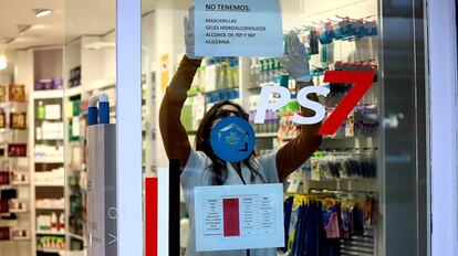 Una farmacéutica cuelga un cartel donde avisa que no le quedan mascarillas ni geles desinfectantes en Platja d'Aro (Girona).