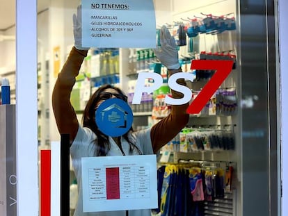 Una farmacéutica cuelga un cartel donde avisa que no le quedan mascarillas ni geles desinfectantes en Platja d'Aro (Girona).  