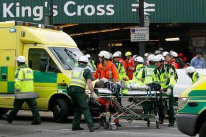 Los servicios de rescate y los servicios médicos evacuan a un herido de la estación de metro de King&#39;s Cross.