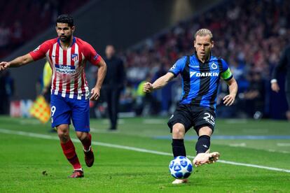 El centrocampista del Brujas Ruud Vormer centra el balón junto a Diego Costa, del Atlético de Madrid.