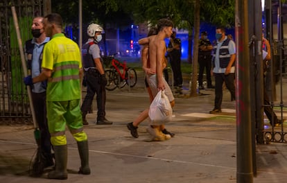 Una pareja de jóvenes pasea por el parque de la España industrial, en Barcelona, este viernes. 