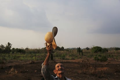 Zezito Oliveira, 83, gestures with his hat, thanking God for his life and his land, on his farm in Rio Pardo next to Bom Futuro National Forest, Rondonia State, Brazil, September 1, 2015. The town of Rio Pardo, a settlement of about 4,000 people in the Amazon rainforest, rises where only jungle stood less than a quarter of a century ago. Loggers first cleared the forest followed by ranchers and farmers, then small merchants and prospectors. Brazil's government has stated a goal of eliminating illegal deforestation, but enforcing the law in remote corners like Rio Pardo is far from easy. REUTERS/Nacho DocePICTURE 35 OF 40 FOR WIDER IMAGE STORY "EARTHPRINTS: RIO PARDO" SEARCH "EARTHPRINTS PARDO" FOR ALL IMAGES