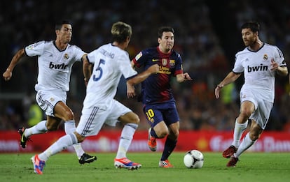 Leo Messi se escapa con el balón de Coentrão, Cristiano Ronaldo y Xabi Alonso, en el partido de vuelta de la Supercopa de 2012.