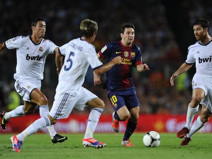 Leo Messi dribbles through Cristiano Ronaldo, Fábio Coentrão and Xabi Alonso during a 2012 UEFA Super Cup match in Spain.