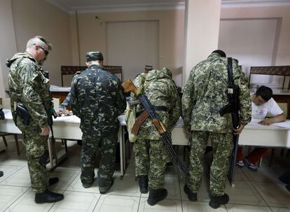 Milicianos armados prorrusos se registran antes de votar en un colegio electoral en Slaviansk.