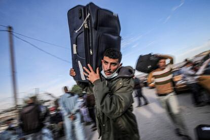 Un hombre camina con una maleta para cruzar la frontera hacia el lado egipcio, a través del paso de Rafah entre la Franja de Gaza y Egipto. El cruce -la única salida de Gaza al exterior que no controla Israel- estará abierto tres días, desde hoy hasta el jueves.