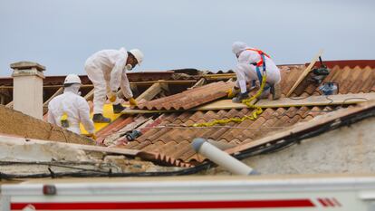 Operarios especializados en la retirada de los tejados de amianto de las tres casas, que se van a derribar en la playa de la babilonia en Guardamar del Segura.