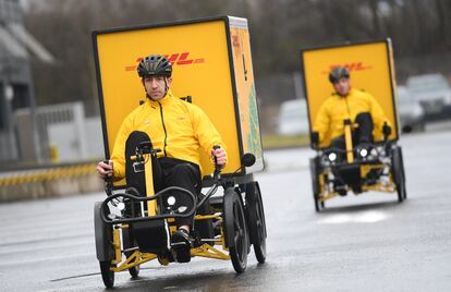 Dos empleados de la empresa de transportes DHL con bicis de reparto en Utrecht.