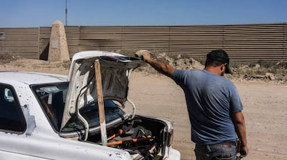 Un hombre frente al muro entre México y Estados Unidos.
