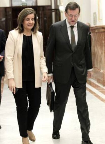 La ministra de Empleo, Fátima Báñez (i), y el jefe del Ejecutivo, Mariano Rajoy (d), en los pasillos del Congreso, donde asisten a la sesión de control al Gobierno.