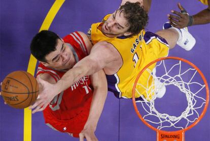 Pau Gasol obstaculiza la entrada a canasta de Yao Ming.