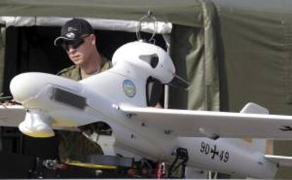 Un soldado de las fuerzas armadas alemanas junto a un "drone" (avión no tripulado) durante los preparativos para el Salón Internacional Aeronáutico ILA en el aeropuerto de Schönefeld, en Alemania, el pasado 10 de septiembre. EFE/Archivo