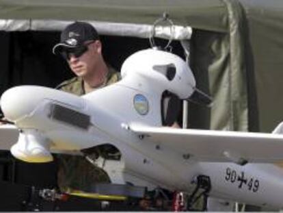Un soldado de las fuerzas armadas alemanas junto a un "drone" (avión no tripulado) durante los preparativos para el Salón Internacional Aeronáutico ILA en el aeropuerto de Schönefeld, en Alemania, el pasado 10 de septiembre. EFE/Archivo
