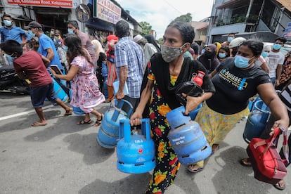 Un grupo de personas bloquea una carretera en Colombo, capital de Sri Lanka, en una protesta por la carestía de bombonas de gas, este sábado.