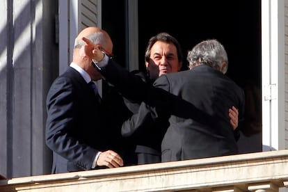 Artur Mas, abrazado a Josep Antoni Duran i Lleida, saluda a los cientos de personas concentradas en la plaza de Sant Jaume