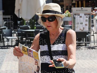 Una turista utiliza el teléfono móvil en el centro de Madrid.