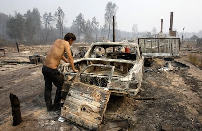 Un hombre mira un vehículo carbonizado por un incendio forestal en la localidad de Peredeltsy, a 180 kilómetors al sur de Moscú.