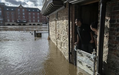 Residentes de Kings Arms observan como el nivel del agua se eleva durante unas inundaciones en las orillas del río Ouse en York (Reino Unido), el 17 de marzo de 2019.