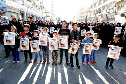 Niños iraníes guardan imágenes de una de las víctimas Mohammad Taha Eghdami, de 4 años, durante un funeral público por el ataque a un desfile militar en el suroeste de Irán.