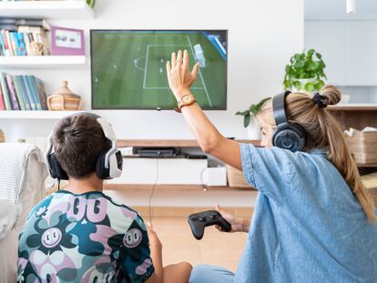 Dos jugadores disfrutan con una videoconsola de mesa en su casa.
