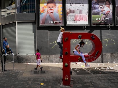 Un grupo de niños juega en la P de un cartel de PDVSA en las calles de Caracas el 2 de enero.