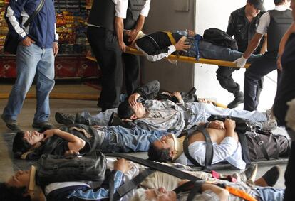 Un grupo de heridos, tendidos en camillas, esperan a ser evacuados en la estación de Once.