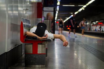 Un hombre descansa  en un banco en la estación de metro de Nuevos Ministerios.