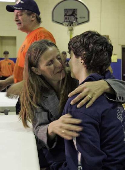 Shawn Hornbeck es abrazado por su madre, Pam, delante de su padrastro.