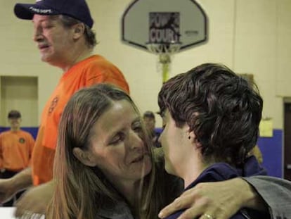 Shawn Hornbeck es abrazado por su madre, Pam, delante de su padrastro.