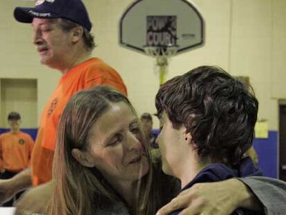 Shawn Hornbeck es abrazado por su madre, Pam, delante de su padrastro.