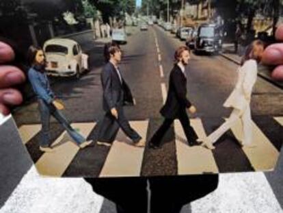 Un guía turístico sostiene la carátula del Abbey Road de Los Beatles