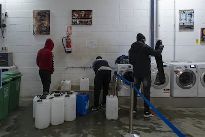 Varios jóvenes cogen agua y lavan ropa en el centro de día que Accem tiene en Palos de la Frontera (Huelva). Allí también les ofrecen desayuno, merienda, ropa, pueden ducharse con toallas desechables y reciben asistencia en la tramitación de su documentación.