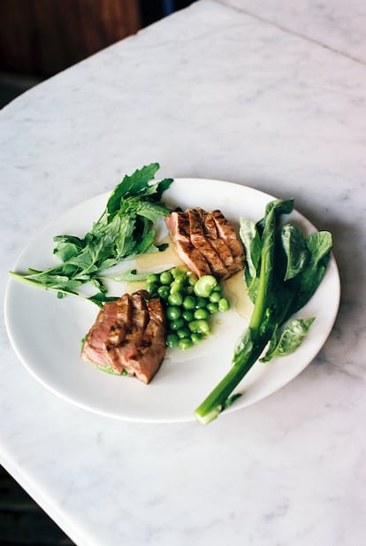 Grilled Berkshire pork with English peas, fava beans in pork broth, and fresh greens is one of the dishes by Chef Ignacio Mattos served at Estela restaurant.