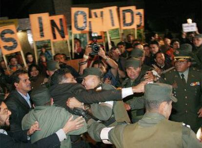 Un grupo de manifestantes intenta alcanzar el coche que traslada a la fiscalía al ex senador Mario Uribe, primo del presidente, el martes en Bogotá.