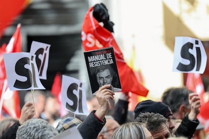 Uno de los simpatizantes concentrados ante la sede del PSOE en Madrid el pasado sábado en apoyo de su secretario general sostiene una copia del libro de Pedro Sánchez.