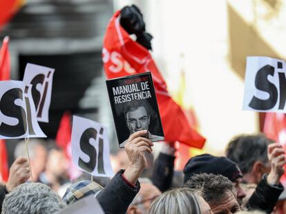 Uno de los simpatizantes concentrados ante la sede del PSOE en Madrid el pasado sábado en apoyo de su secretario general sostiene una copia del libro de Pedro Sánchez.